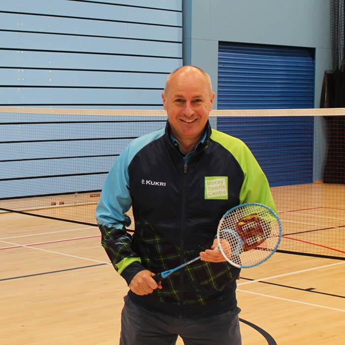 one of the staff members holding a badminton racket